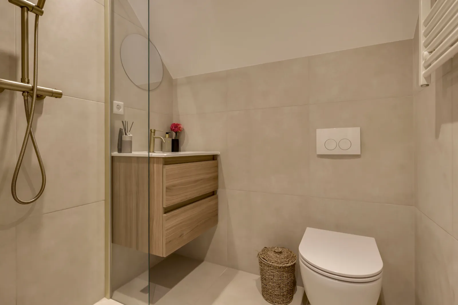 Badkamer van de modelwoning met inloopdouche en zwevend houten wastafelmeubel